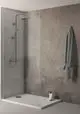 Duschsystem von Ideal Standard mit Glaswand, Kopfbrause und Handbrause, montiert in einem modernen Badezimmer mit grauem Wanddesign und neutraler Ausstattung.